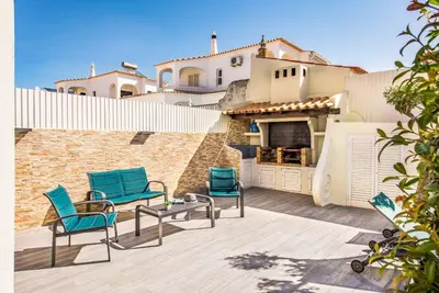 a patio with two chairs and a table and a building at Villa Marquesa in Guia