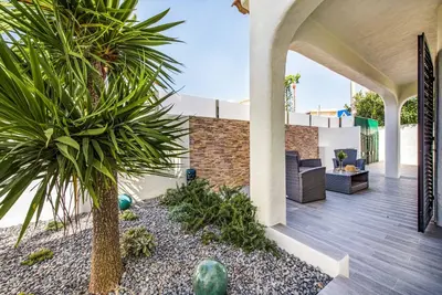 an outdoor patio with a palm tree on a house at Villa Marquesa in Guia