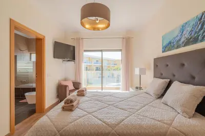 a bedroom with a large bed with a large window at Jardins Marina Stars in Albufeira