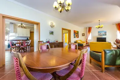 a dining room with a wooden table and chairs at Villa Amarela in Boliqueime