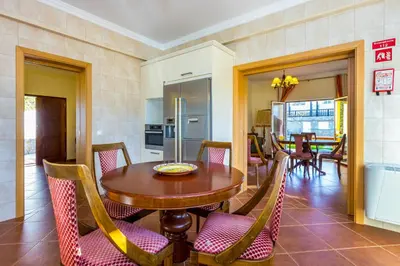 a kitchen and dining room with a wooden table and chairs at Villa Amarela in Boliqueime