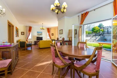 a living room with a wooden table and chairs at Villa Amarela in Boliqueime