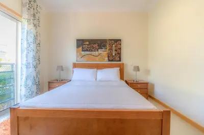 a bedroom with a bed with a wooden headboard at #004 Orada by Home Holidays in Albufeira