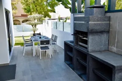 a patio with a fireplace and a table and chairs at Amora Villa Sacha in Vilamoura