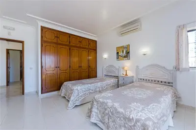 a bedroom with two beds and a wooden door at Villa Mirante in Albufeira