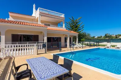 a villa with a swimming pool and a house at Villa Mirante in Albufeira