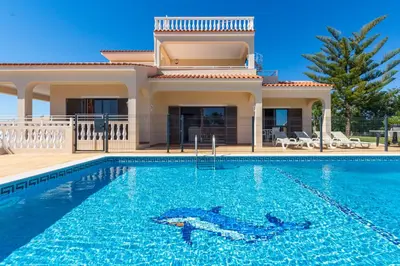 a villa with a swimming pool in front of a house at Villa Mirante in Albufeira