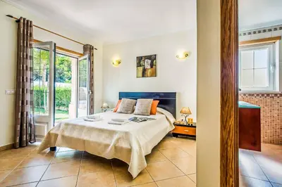 a bedroom with a bed and a large window at Villa Luana in Olhos de Água