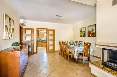 a kitchen and dining room with a table and chairs at Villa Luana in Olhos de Água