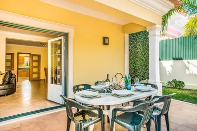 a dining room with a table and chairs at Villa Luana in Olhos de Água