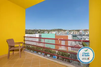 a balcony with a chair and a view of the water at Villa 14 Marina de Albufeira in Albufeira