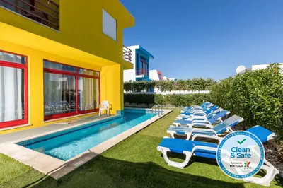 a row of lounge chairs next to a swimming pool at Villa 14 Marina de Albufeira in Albufeira