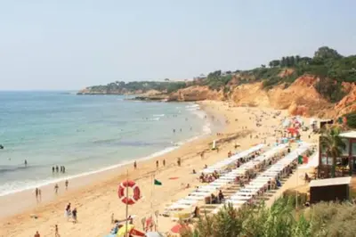 a beach with a lot of people and the ocean at Oasis in Olhos de Agua in Branqueira