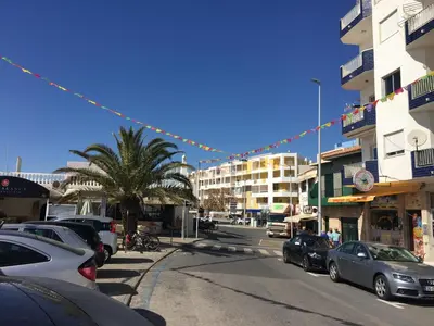 a street with cars parked on the side of the road at Apt 2 Quartos, BBQ, AC, Varanda, Prestige For Home in Quarteira