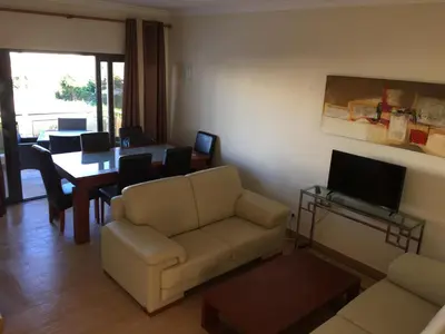 a living room with a couch and a table at Apt 2 Quartos, BBQ, AC, Varanda, Prestige For Home in Quarteira