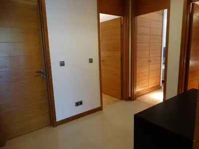 a hallway with wooden doors and a black table at Apartamento com 3 quartos e piscina in Vale do Lobo