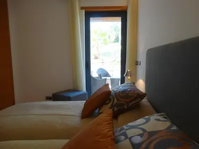 a bedroom with two beds and a window at Apartamento com 3 quartos e piscina in Vale do Lobo