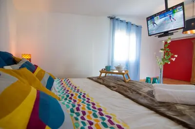 a bed with a colorful blanket and a tv in a room at villa yvonne,private pool,private parking 1,7 km from the beach in Albufeira