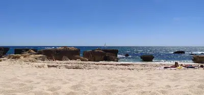 a group of people laying in the sand on a beach at Sea View 3 in Albufeira