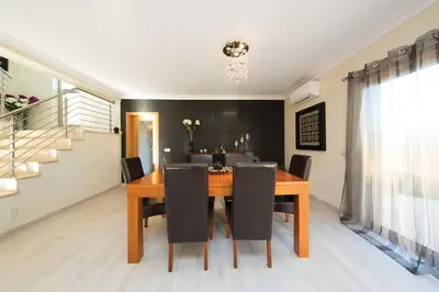a dining room with a wooden table and chairs at Villa Lote 7 by Gabi Miguel in Guia