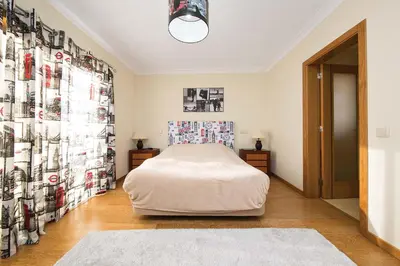 a bedroom with a bed and a wall of pictures at Villa Lote 7 by Gabi Miguel in Guia
