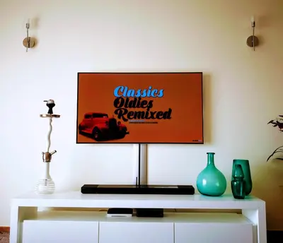 a tv screen on a wall with a white table at Spacious apartment in Albufeira with pool and terrace in Albufeira