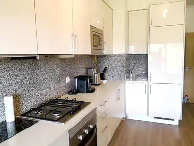 a kitchen with white cabinets and a stove top oven at Spacious apartment in Albufeira with pool and terrace in Albufeira