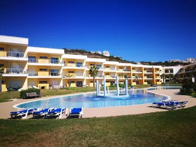 a large apartment building with a swimming pool and lounge chairs at Spacious apartment in Albufeira with pool and terrace in Albufeira