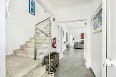 a hallway with white walls and a staircase with wooden floors at Villa Jomar in Guia