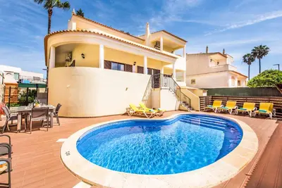 a villa with a swimming pool in front of a house at Villa Simoes in Guia