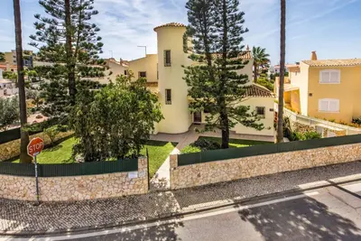 a house with a fence and trees and a stop sign at Villa Simoes in Guia