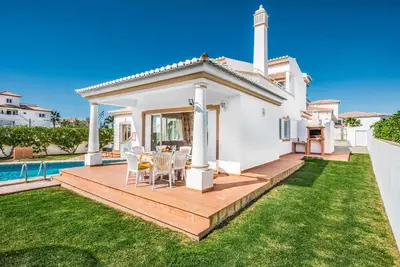 a white house with a deck and a swimming pool at Villa Damara in Albufeira