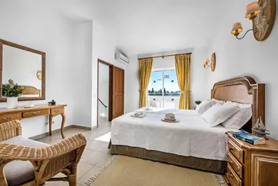 a bedroom with a bed and a desk and a mirror at Villa Damara in Albufeira