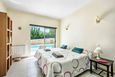 a bedroom with a bed and a swimming pool at Villa Sao Joao in Caliços