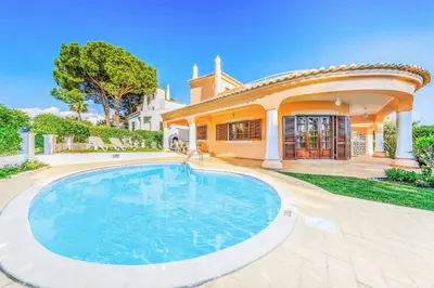 a large swimming pool in front of a house at Villa Ponderosa in Quarteira