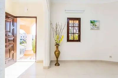 a vase with yellow flowers in a hallway at Villa Ponderosa in Quarteira