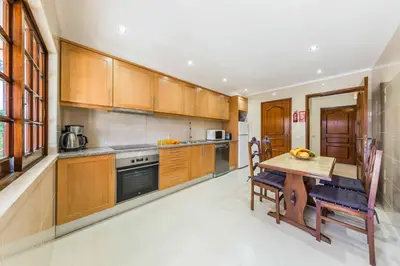 a kitchen with wooden cabinets and a wooden table at Villa Ponderosa in Quarteira