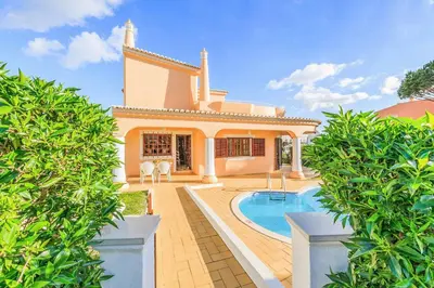 a villa with a swimming pool and a house at Villa Ponderosa in Quarteira