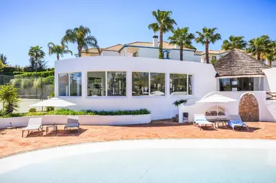 a villa with a swimming pool and a house at Encosta Do Lago Resort Club in Quinta do Lago