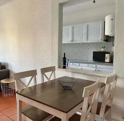 a kitchen with a table and chairs in a room at Apartamento bem localizado in Albufeira