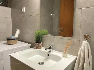 a bathroom with a sink and a mirror at Apartamento bem localizado in Albufeira