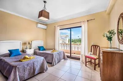 a hotel room with two beds and a balcony at Villa Charlota in Albufeira