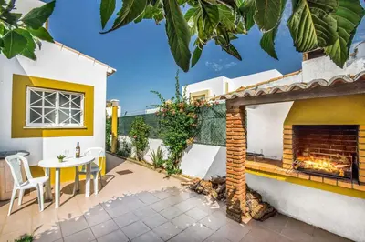 a patio with a table and a fireplace at Villa Arines in Albufeira