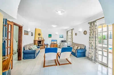 a living room with blue chairs and a table at Villa Arines in Albufeira