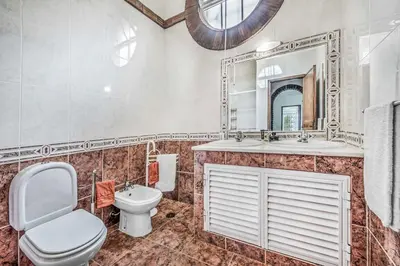 a bathroom with a toilet and a sink and a mirror at Villa Arines in Albufeira