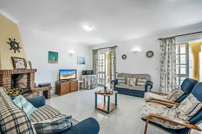 a living room with blue furniture and a fireplace at Villa Arines in Albufeira