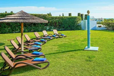 a dining room and living room with a table and chairs at Villa Beatrice in Albufeira