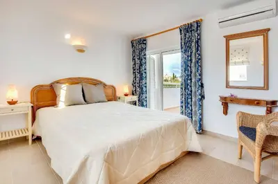 a bedroom with a large bed and a balcony at Villa Beatrice in Albufeira