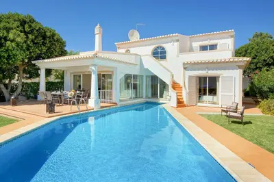 a swimming pool in front of a house at Villa Adele in Albufeira