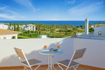 a table with two glasses of wine on a balcony at Villa Adele in Albufeira